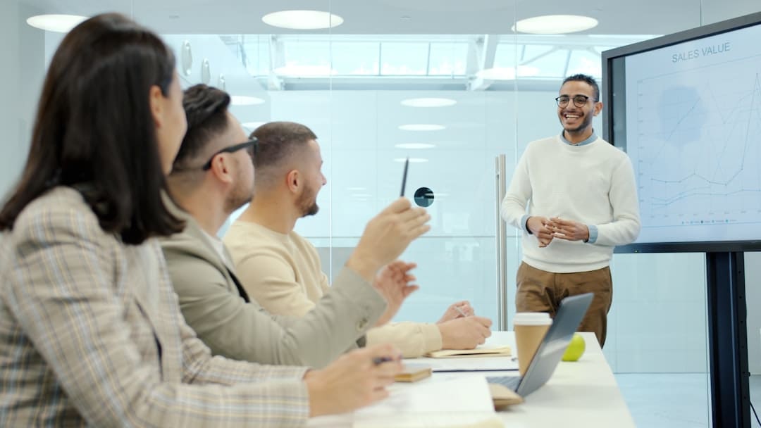 emotional support animals — Man presenting to colleagues in a modern office setting