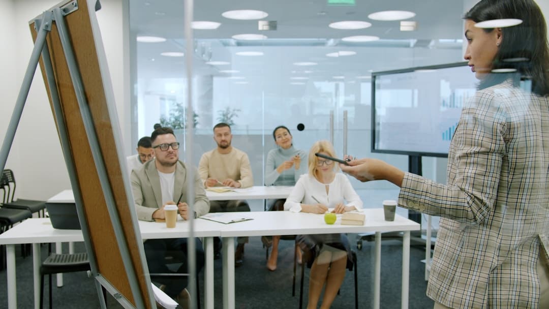 emotional support animals — Woman presenting to a group in a modern office.