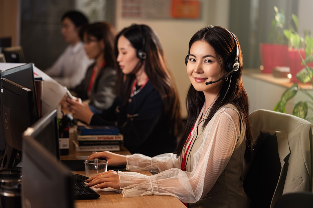 service dog incident — A smiling woman wearing a headset at a computer
