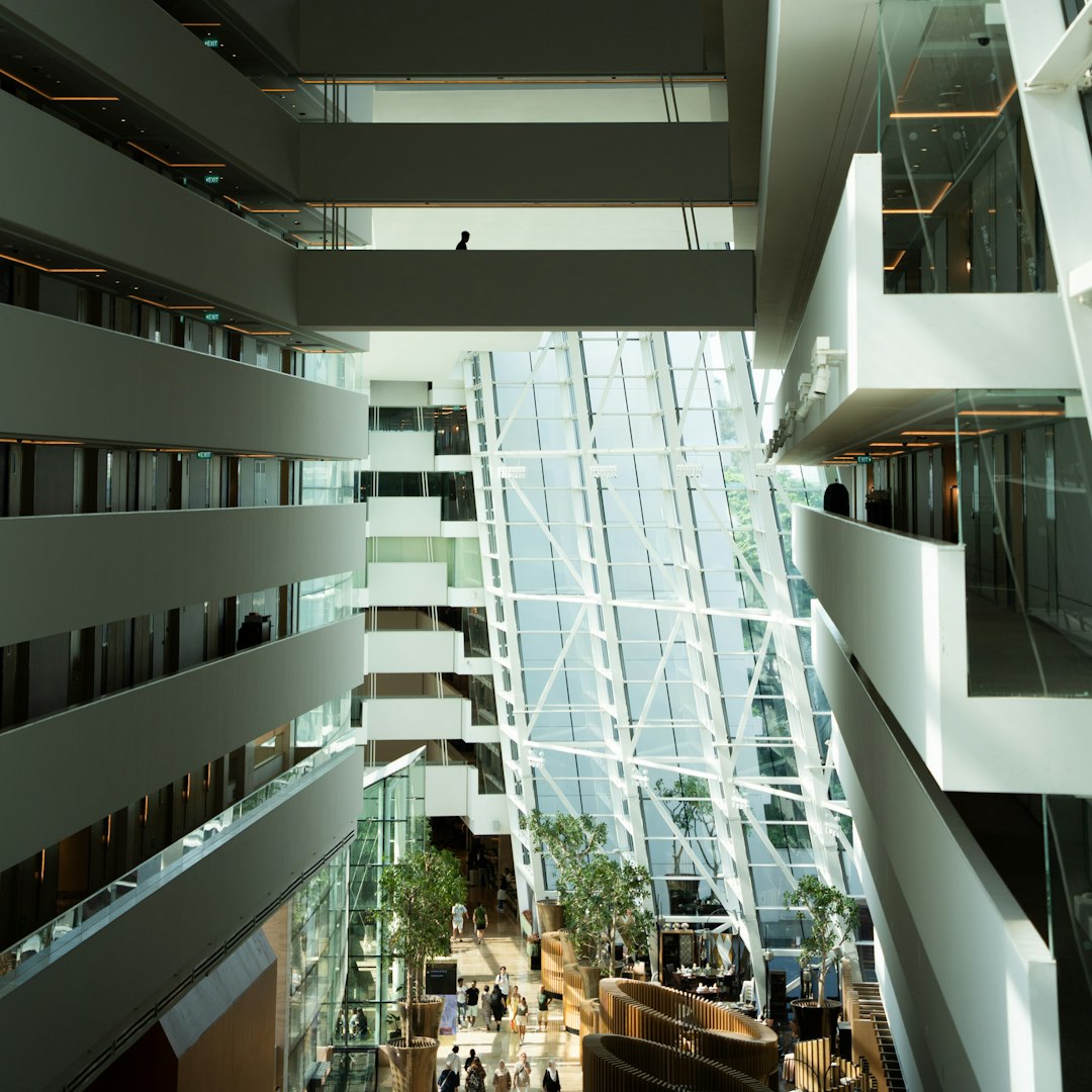 service dog access — Modern atrium with glass elevator and balconies
