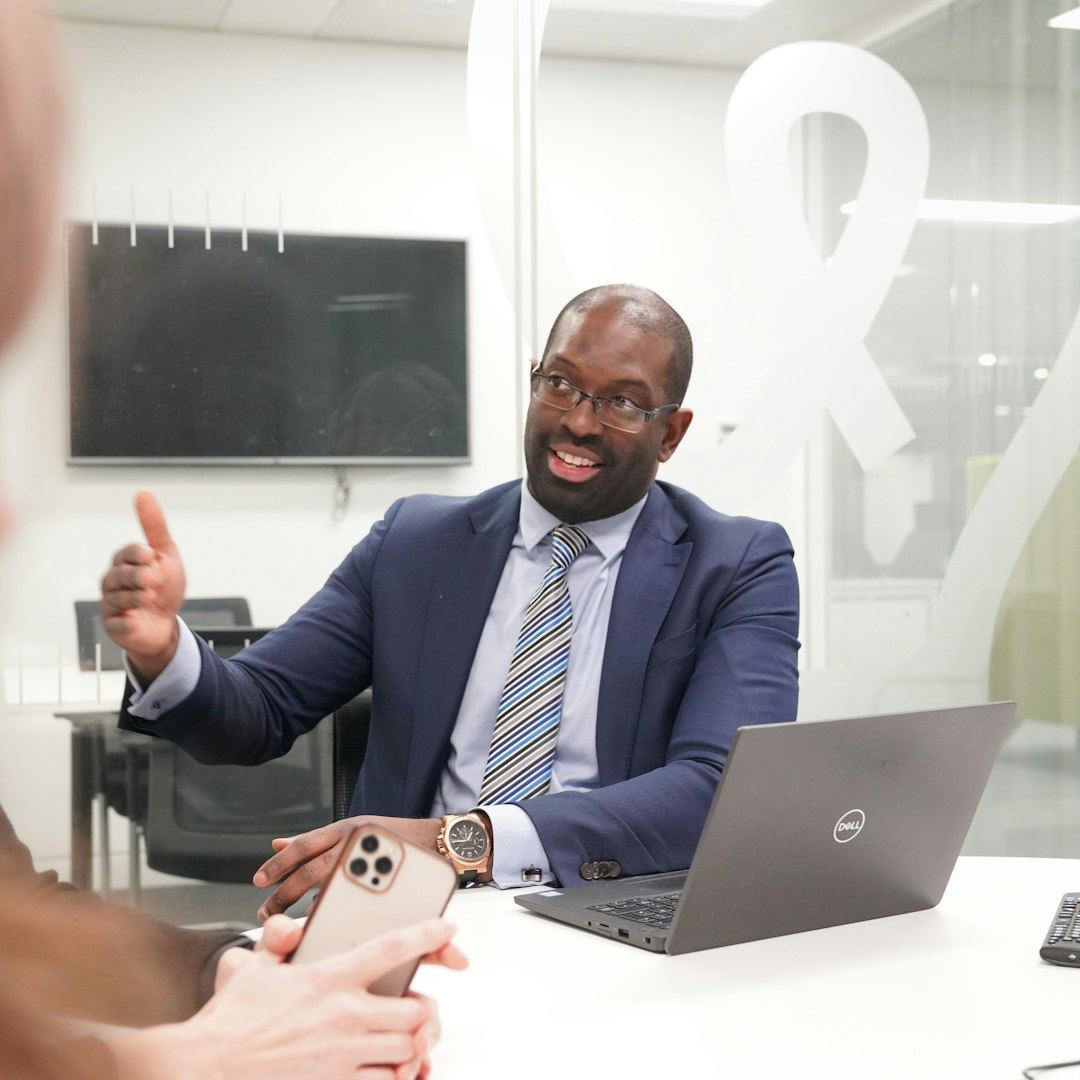 service dog vs emotional support animal — A man in a suit and tie gesturing during a meeting in an office